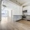 open concept living room with large windows adjacent to kitchen