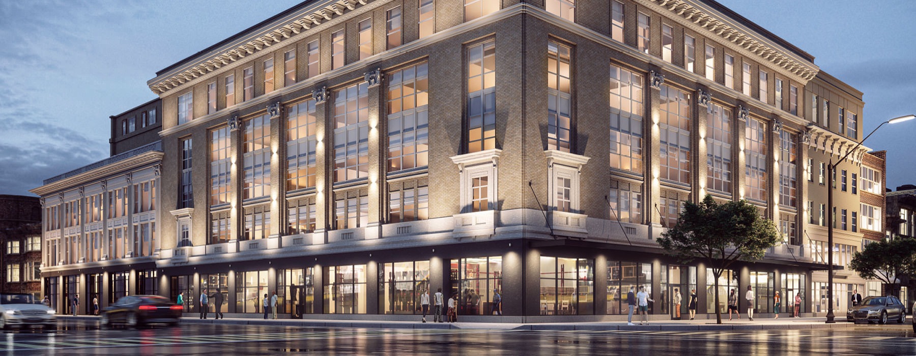 rendering of building exterior lit at night on corner lot